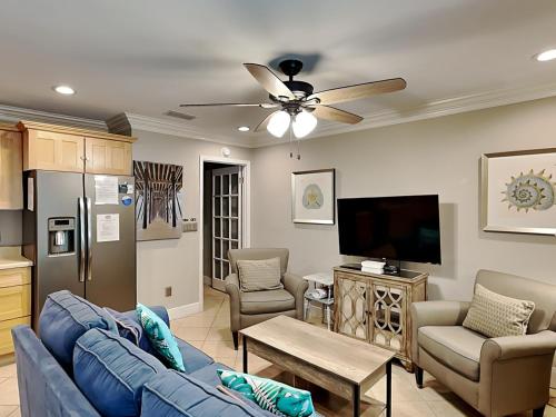 a living room with a blue couch and a tv at Inlet Dunes #102 in Inlet Beach