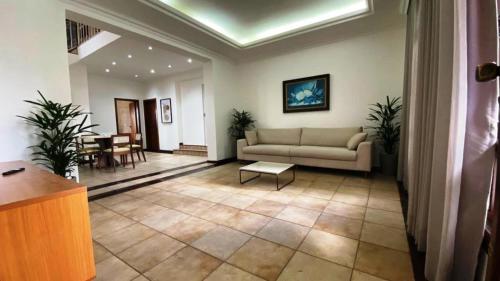 a living room with a couch and a table at Hostel com Piscina - Carlos Prates - Belo Horizonte in Belo Horizonte