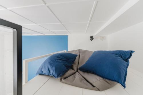 two blue pillows sitting on a couch in a room at L'Estival, T2 à 5min de la gare avec WIFI in Lens