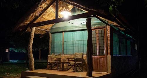 a gazebo with a table and chairs in the night at Thornicroft Lodge - South Luangwa in Mpanda
