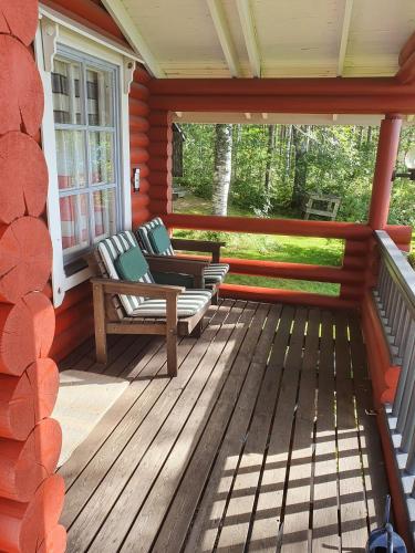 a screened in porch with two chairs on it at Villa Lahtela in Kajaani