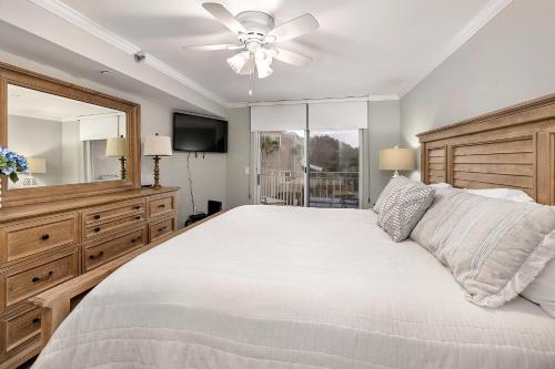 Un dormitorio con una cama grande y un ventilador de techo. en North Breakers #302, en Saint Simons Island