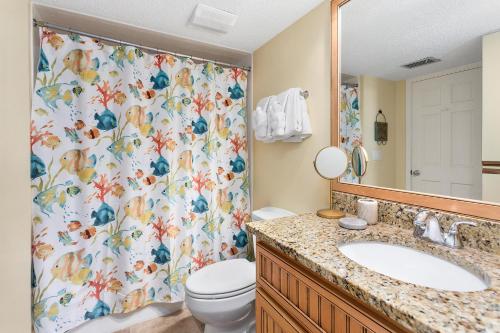Un baño con cortina de ducha con inodoro y lavabo. en North Breakers #300, en Saint Simons Island
