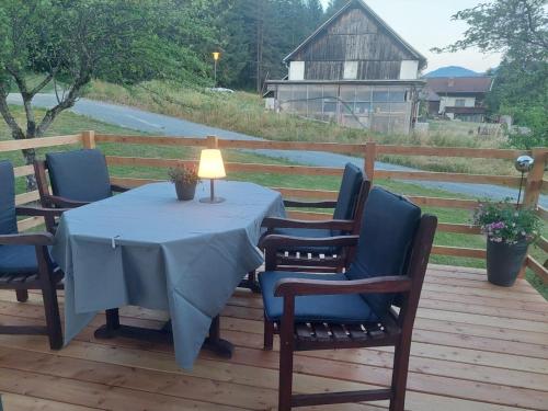 a table with chairs and a lamp on a deck at Landhaus Seppi in Presseggersee