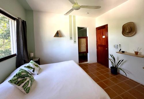 a bedroom with a white bed and a window at Sirenas Caribbean Rooms Holbox in Holbox Island