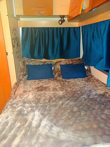 a large bed with blue pillows in a bedroom at Little forest home 