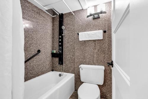 a bathroom with a toilet and a tub and a sink at Aztec Ocean Resort in Seaside Heights