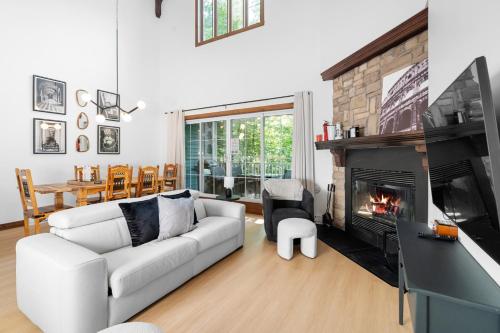 a living room with a couch and a fireplace at Les Manoirs 3bdrs Near Village in Mont-Tremblant