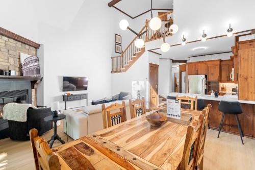 a kitchen and dining room with a wooden table at Les Manoirs 3bdrs Near Village in Mont-Tremblant
