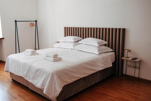 a bedroom with a large bed with white sheets and pillows at Nono Ban West Coast in Split