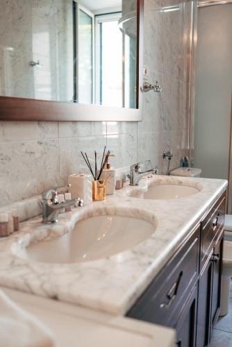 a bathroom with two sinks and a mirror at Nono Ban West Coast in Split