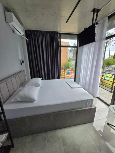 a bedroom with a bed and a large window at Blue Horizon Apartments in Ureki