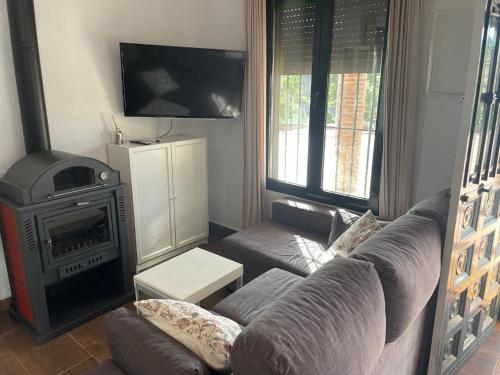 a living room with a couch and a stove at TIERRA NUEVA Familiar experience in Torre de Benagalbón
