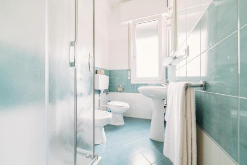 a bathroom with a toilet and a sink and a mirror at Residence Comfort in Lido di Jesolo