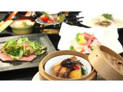 a table with a bowl of food and plates of food at Hotel Symphony - Vacation STAY 31575v in Sagae