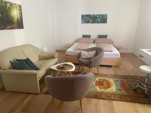 ein Schlafzimmer mit einem Bett, einer Couch und Stühlen in der Unterkunft Dein Rückzugsort in der Pfalz in Ruppertsberg