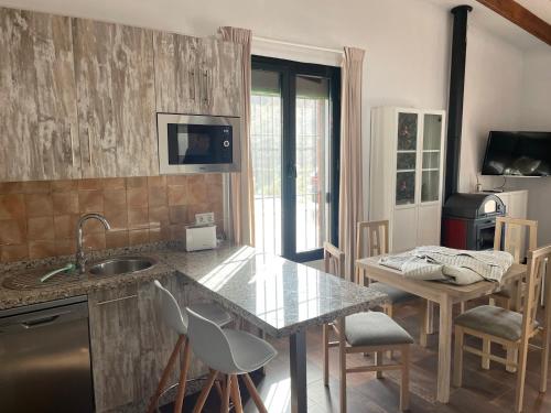 a kitchen with a counter and a table and chairs at TIERRA NUEVA Familiar experience in Torre de Benagalbón