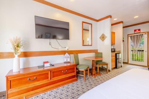 a hotel room with a bed and a tv on the wall at Qualla Cabins and Motel Cherokee near Casino in Whittier