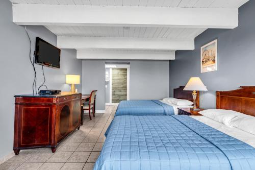 a hotel room with two beds and a flat screen tv at Aztec Ocean Resort in Seaside Heights