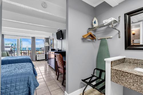 a bedroom with a bed and a bathroom with a sink at Aztec Ocean Resort in Seaside Heights