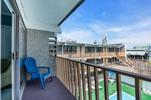 a balcony with a blue chair and a building at Aztec Ocean Resort in Seaside Heights