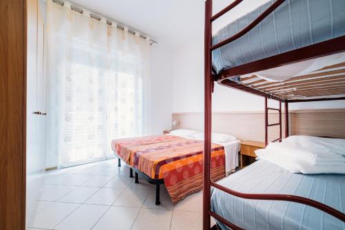 1 dormitorio con 2 literas y ventana en Residence Comfort, en Lido di Jesolo