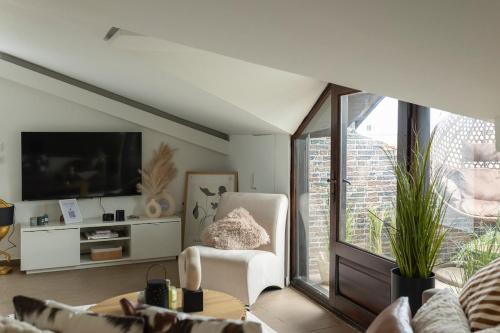 Una sala de estar con una silla y un televisor. en my sofita luxury stay, en Édessa