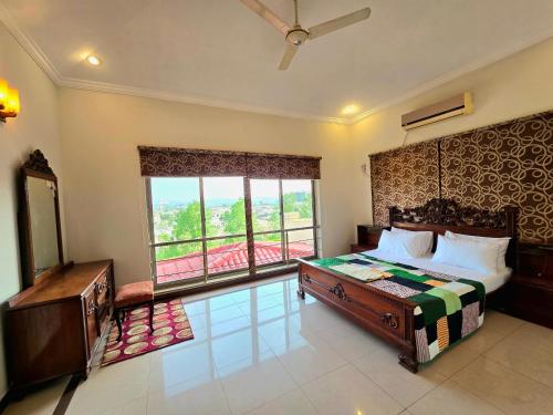 a bedroom with a bed and a large window at Eden Grove Villa in Rawalpindi
