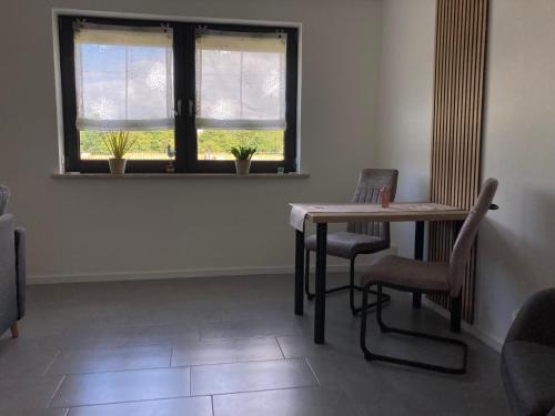 a dining room with a table and chairs and a window at Ferienwohnung Christel in Upahl