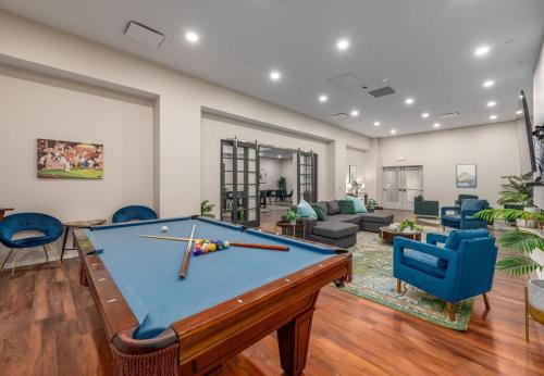 a living room with a pool table and blue chairs at Luxury Condo l DT l Playhouse Square l Sofa Bed in Cleveland