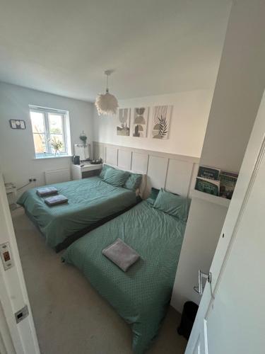 a bedroom with a green bed and a window at Room in house close to Dover port in Temple Ewell