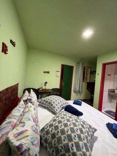 a bedroom with a bed with pillows on it at Pousada Morango das Palmas in Praia de Palmas