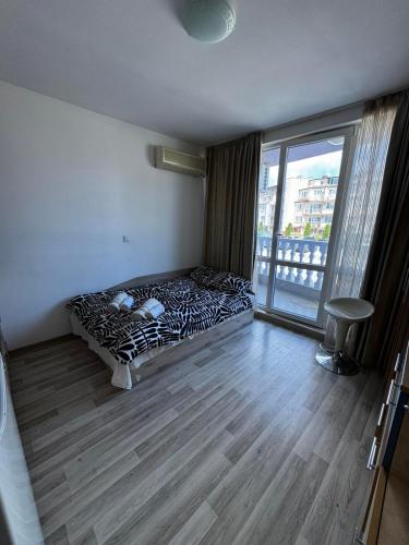 a bed in a room with a window and a bed sidx sidx sidx at Aurora 1 Bedroom beach Apartment in Nesebar