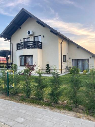a white house with a fence in front of it at Cazare Băile Figa -The Home DRM in Beclean