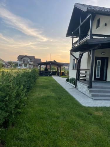a house with a gazebo next to a yard at Cazare Băile Figa -The Home DRM in Beclean