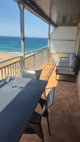 a balcony with a table and chairs and the ocean at Apto en 1ª linea de playa, Bakio in Bakio