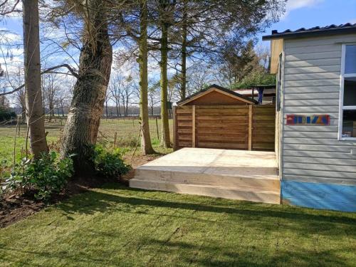 a wooden garage next to a house at Ibiza chalet in natuurlijke omgeving in Bergen op Zoom