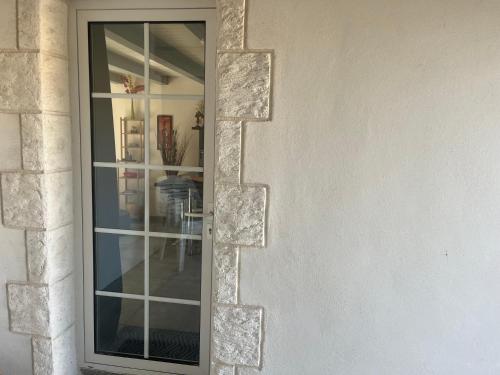 une porte en verre dans un mur en pierre avec une fenêtre dans l'établissement Dorian, à Pornic