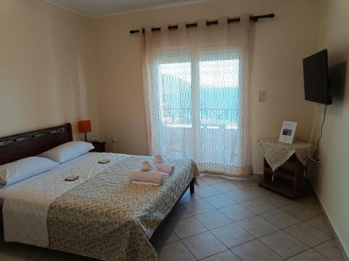 a bedroom with a bed with a stuffed animal on it at GEOMELOS Georgios APARTMENTS CHIOS in Chios