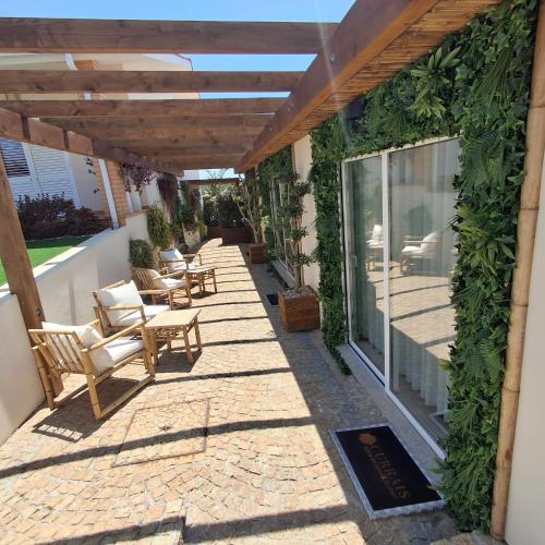 an outdoor patio with chairs and a pergola at Currais o pequeno paraíso entre o mar e a serra in Aveiro