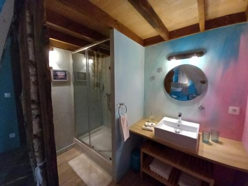 a bathroom with a sink and a shower at Aux quatre coins du monde in Champvoux