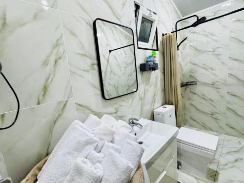 a bathroom with a sink and a mirror and towels at Mansard 91 in Sergeli Bekati