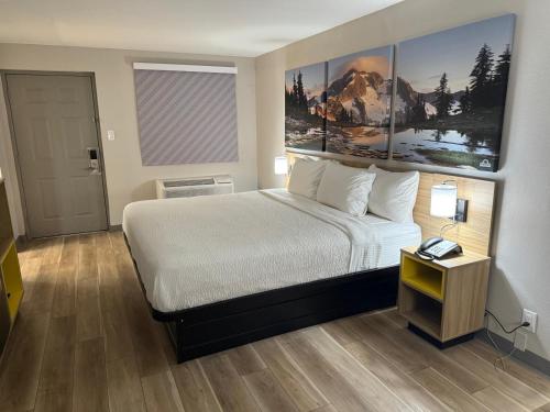 a hotel room with a large bed and a table at Days Inn by Wyndham Reno in Reno