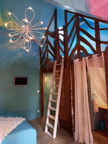 a bedroom with a wooden bunk bed with a ladder at Aux quatre coins du monde in Champvoux