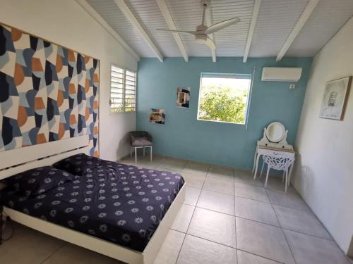 a bedroom with a bed and a blue wall at Villa CYNNE Paradis Tropical in Baie-Mahault