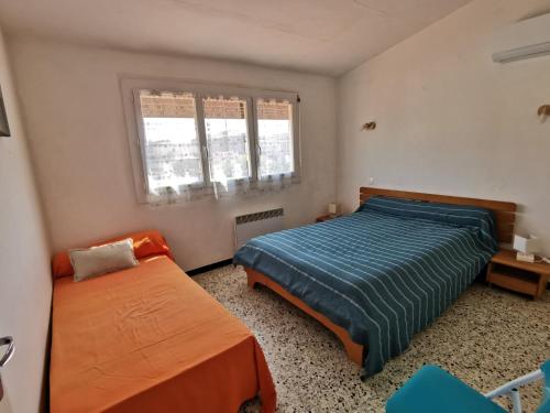 une chambre avec deux lits et deux fenêtres dans l'établissement Pavillon T3 proche de la plage TERRASSE GARAGE PARKING, à Port-la-Nouvelle