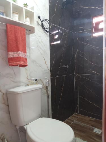 a bathroom with a white toilet and a shower at Chalé Vista da Serra in Pedro II