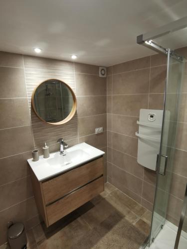 une salle de bain avec un lavabo, un miroir et une douche dans l'établissement Charmant Appartement Neuf, à LʼArgentière-la-Bessée