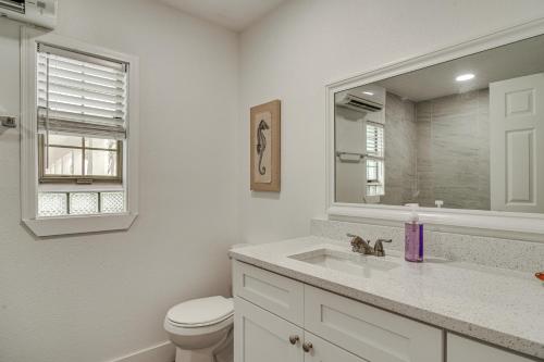 a bathroom with a toilet and a sink and a mirror at Bright Gulf Coast Escape - 8 Mi to Johns Pass! in St Pete Beach