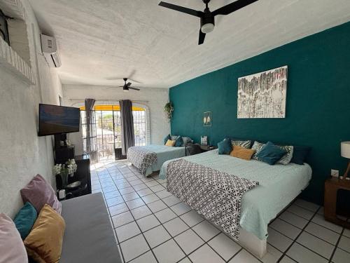 a bedroom with two beds and a blue wall at Nueva Vista INN in Cruz de Huanacaxtle
